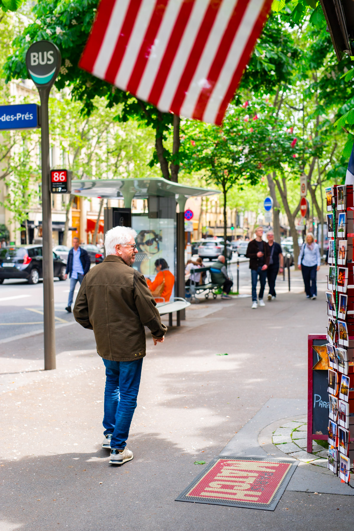Stroll the Boulevard Saint Germain, man walking past news stand Things to do in Saint Germain de Pres
